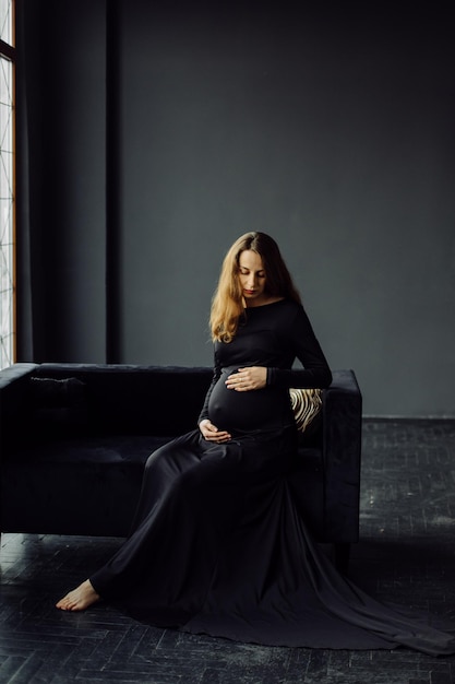 Belle jeune femme enceinte en robe noire Concept de look de mode de grossesse