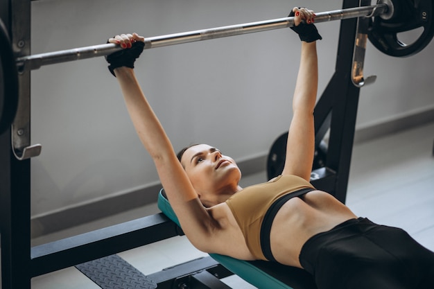 Belle jeune femme exerçant au gymnase