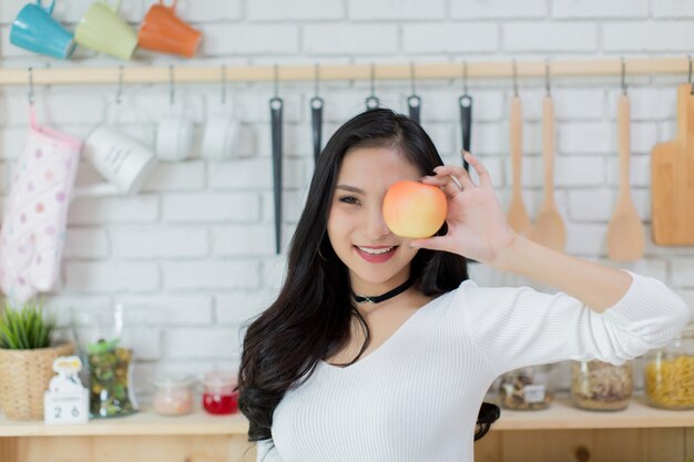 Belle jeune femme faisant un choix entre un gâteau et une pomme