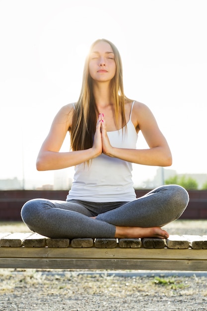 Belle jeune femme faisant du yoga dans la rue.