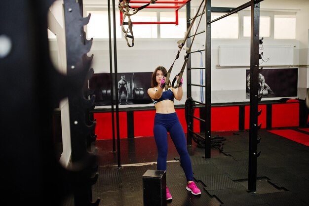 Belle jeune femme faisant des exercices et travaillant dur dans la salle de gym et appréciant son processus d'entraînement