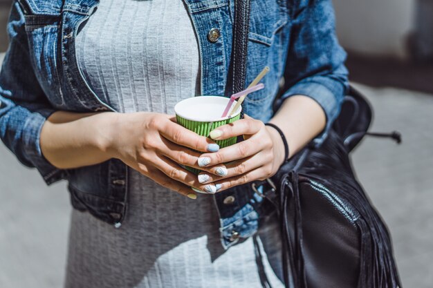 belle jeune femme frisée à l&#39;extérieur de marcher et de boire du café.