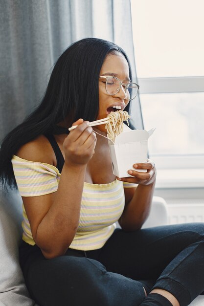 Belle jeune femme mangeant des nouilles