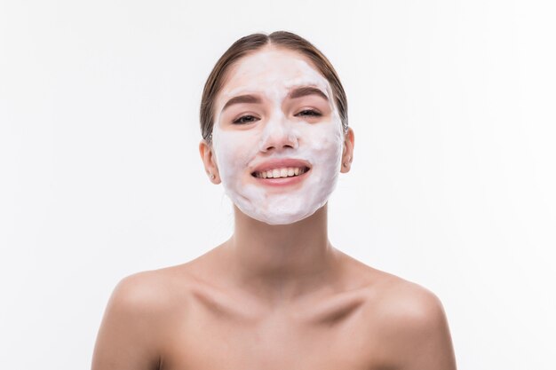 Belle jeune femme avec masque facial sur mur blanc