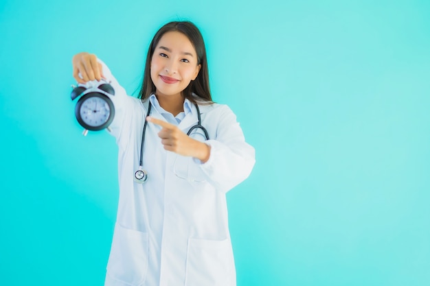 belle jeune femme médecin asiatique avec horloge ou alarme