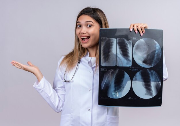 Belle jeune femme médecin vêtu d'un blouse blanche avec stéthoscope tenant x-ray des poumons