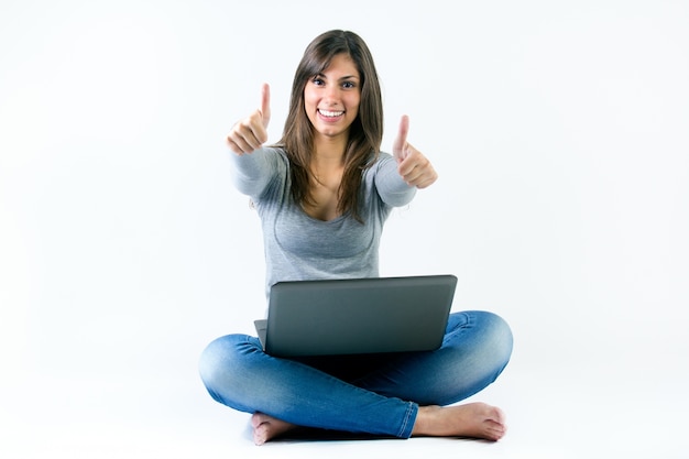 Belle jeune femme avec un ordinateur portable en studio