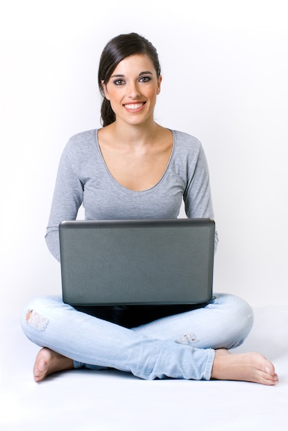 Belle jeune femme avec un ordinateur portable en studio