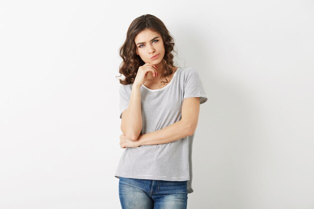 Belle jeune femme, pensant au problème, style hipster, vêtue de jeans, t-shirt, isolé sur fond blanc