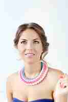 Photo gratuite belle jeune femme portant un collier coloré et pensant