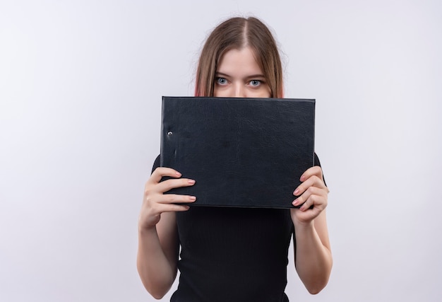 Belle jeune femme portant un t-shirt noir visage couvert avec presse-papiers sur mur blanc isolé