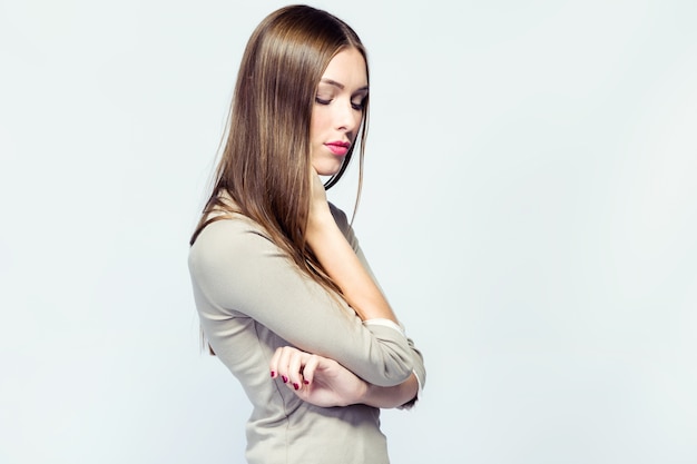 Belle jeune femme posant sur fond blanc.