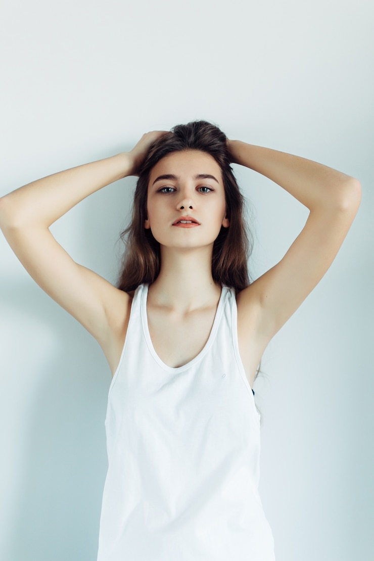 Photo gratuit belle jeune femme posant sur un mur blanc