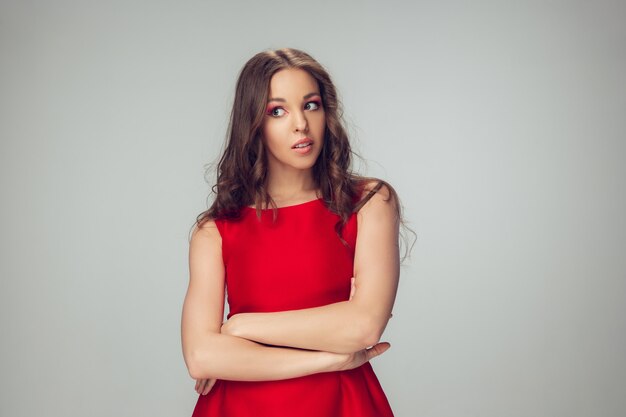 Belle jeune femme posant avec une robe rouge