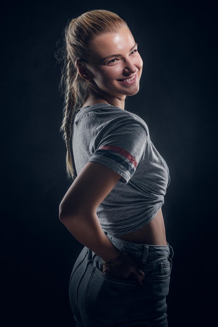 Photo gratuit belle jeune femme pose pour le photographe au studio photo sombre.