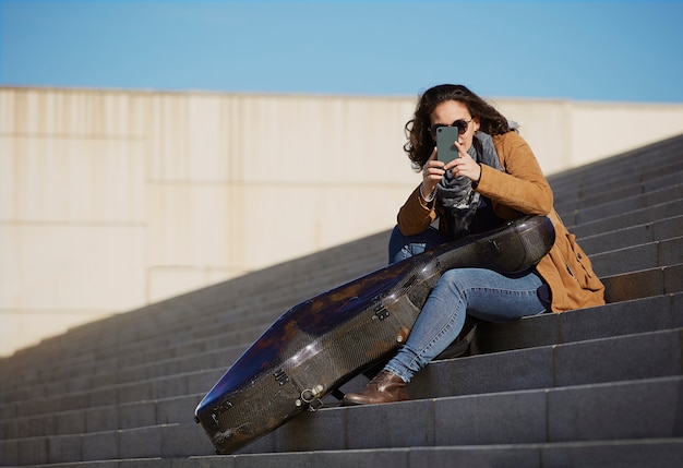 Belle jeune femme prenant une photo avec son téléphone portable.