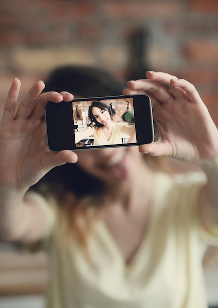 Belle jeune femme prenant selfie avec smartphone