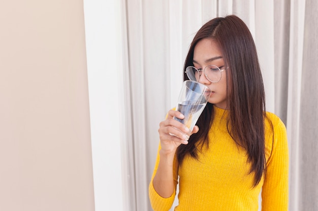 Belle jeune femme qui boit de l&#39;eau