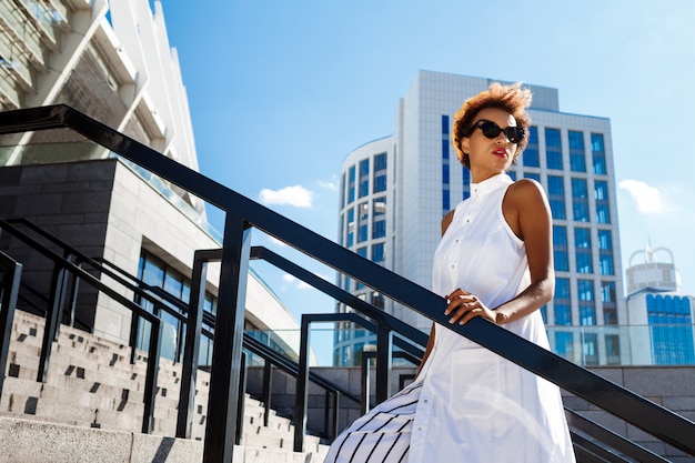 Belle jeune femme qui monte les escaliers en descendant la ville