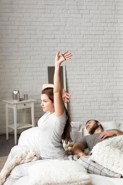 Photo gratuite belle jeune femme qui s'étend au lit