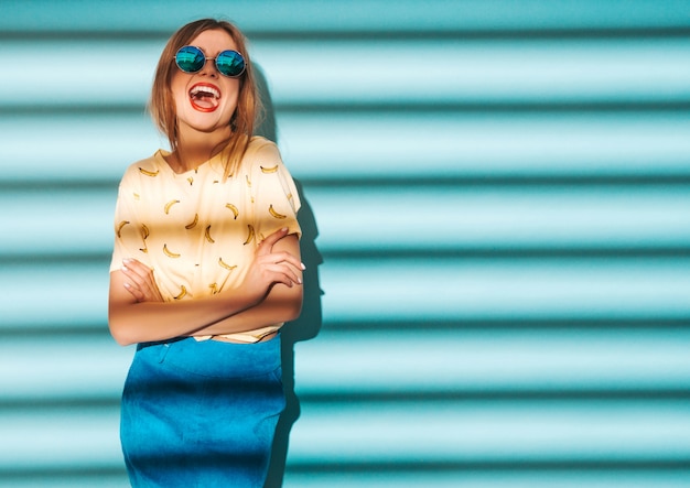 Belle jeune femme à la recherche. Fille à la mode dans des vêtements décontractés de T-shirt jaune d'été.