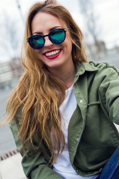 Belle jeune femme regarde la caméra dans la rue.