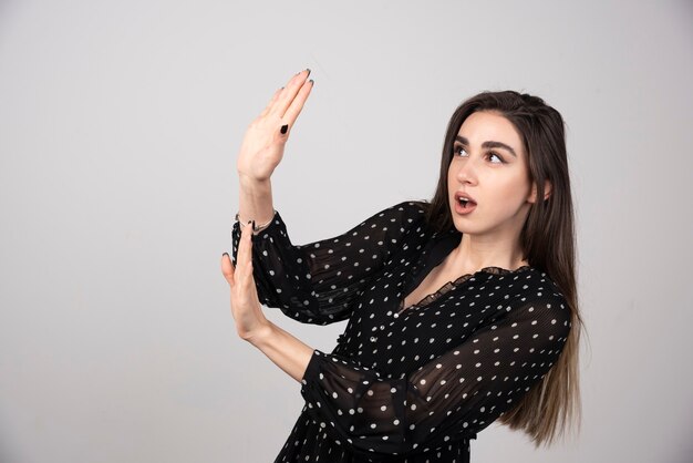 Belle jeune femme s'éloignant des paumes des mains montrant le refus et le déni.