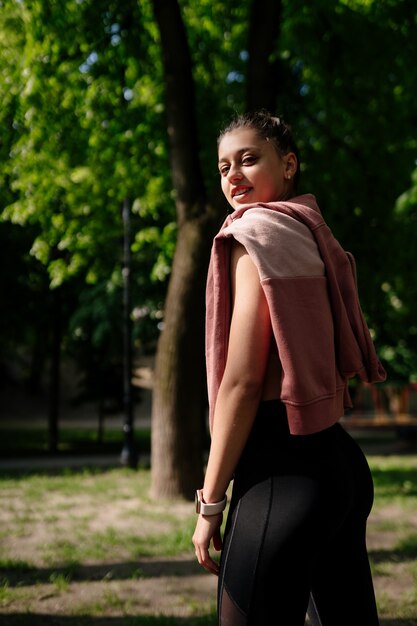 Belle jeune femme se repose après le jogging dans le parc.