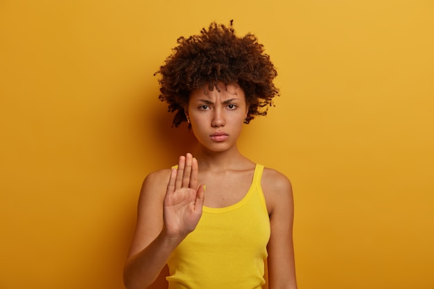 Photo gratuite belle jeune femme sérieuse exige de tenir et fait l'interdiction