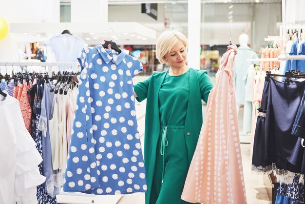 Belle jeune femme souriante fait le choix lors de vos achats dans un magasin