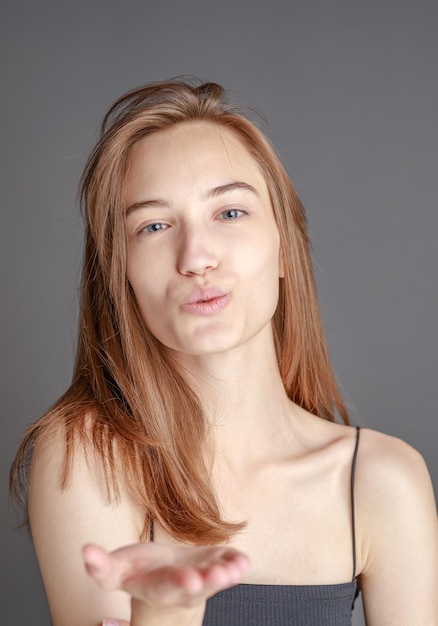 Belle jeune femme souriante avec une peau parfaite visage beauté naturelle concept isolé sur fond de studio