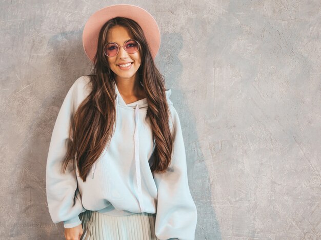 Belle jeune femme souriante à la recherche. Fille à la mode dans des vêtements décontractés à capuche et jupe d'été.