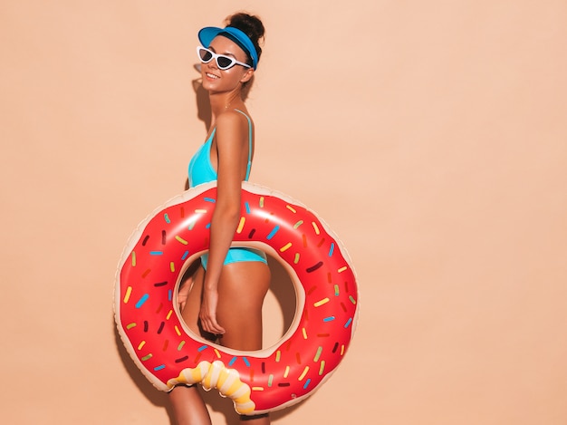 Belle jeune femme souriante sexy hipster en lunettes de soleil. Fille en maillot de bain d'été maillot de bain avec matelas gonflable donut lilo. Femme positive devenant folle.