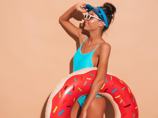 Photo gratuite belle jeune femme souriante sexy hipster en lunettes de soleil. fille en maillot de bain d'été maillot de bain avec matelas gonflable donut lilo. femme positive devenant folle.