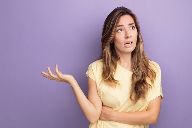 Belle jeune femme en t-shirt beige à côté confondu avec le bras