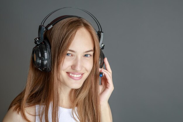 Belle jeune femme en tenue lumineuse appréciant la musique à la maison