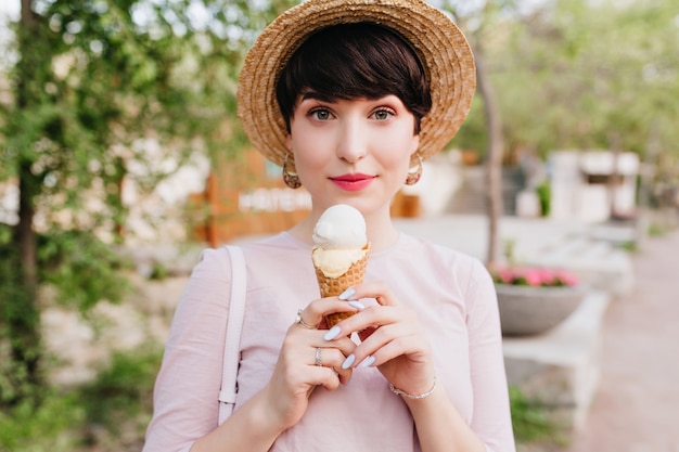 Belle Jeune Femme En Tenue Vintage Avec Manucure élégante Marchant Dans La Rue Et Mangeant De La Glace à La Vanille Avec Plaisir