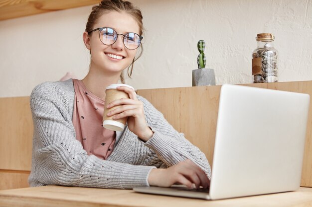 Belle jeune femme travaillant avec un ordinateur portable