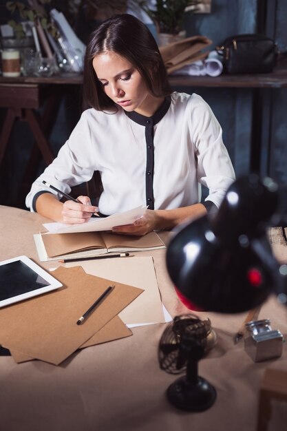 Belle jeune femme travaillant avec une tasse de café