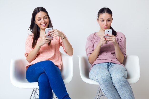 Belle jeune femme utilisant son téléphone mobile à la maison.