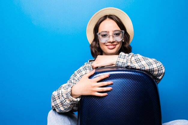 Belle jeune femme avec valise avec lunettes de soleil et chapeau de paille prêt pour le voyage d'été