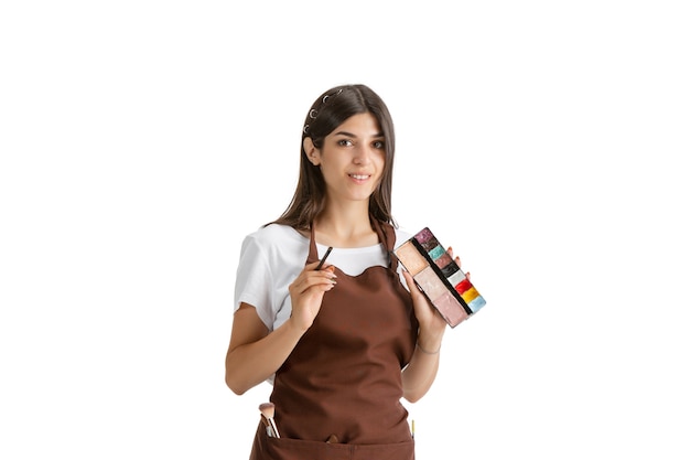 Belle jeune femme, visagiste avec des cosmétiques isolé sur blanc studio