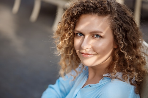 Belle jeune fille assise au café.