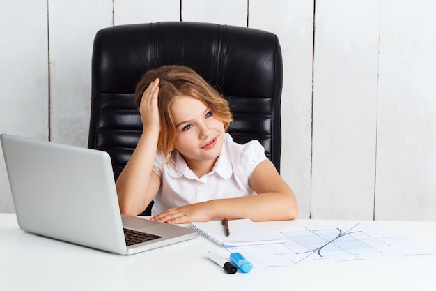 Belle jeune fille assise au lieu de travail au bureau.