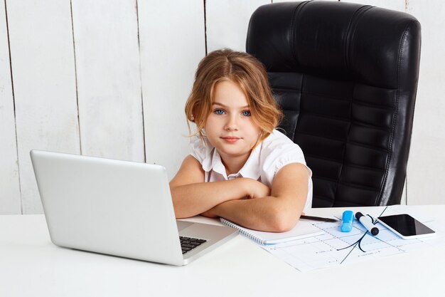 Belle jeune fille assise au lieu de travail au bureau.