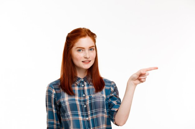 belle jeune fille au gingembre sur mur blanc.