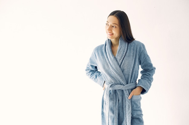 Photo gratuite belle jeune fille debout dans un studio dans un peignoir bleu