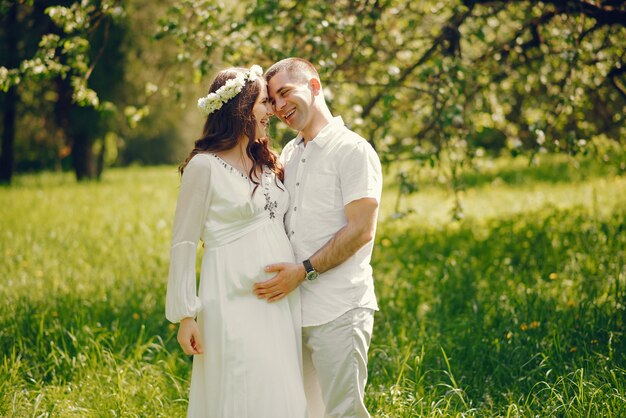 belle jeune fille enceinte dans une longue robe blanche avec son petit ami