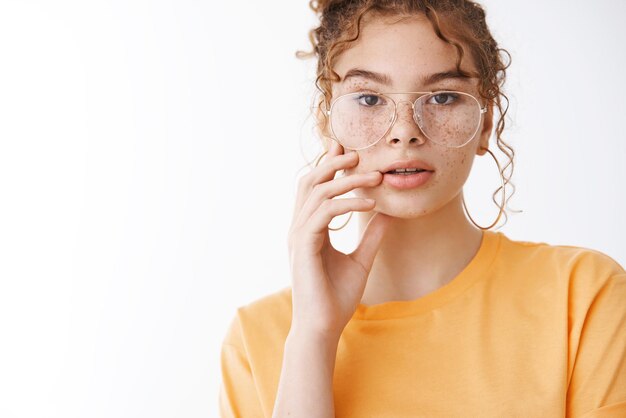 Belle jeune fille européenne rousse tachée de rousseur touchant une peau propre et pure regarder la caméra debout