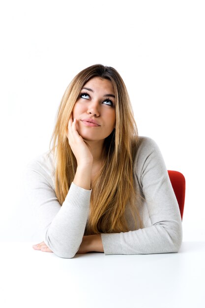 Belle jeune fille regarde la caméra. Isolé sur blanc.